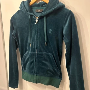 Juicy catoure dress - Jättebra skick och supersnygg färg den är använd men väldigt bra kvalite endå inga hål eller så bara ett snöra på byxan som saknar silver metall biten.