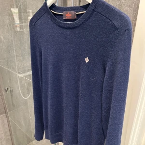 Mörkblå tröja i merinoull från Morris - Säljer en stilren mörkblå tröja från Morris i 100% merinoull. Tröjan har en liten broderad detalj på bröstet och rund halsringning. Perfekt för kyligare dagar. Storlek M men sitter som S!