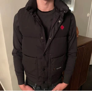  canada goose väst - Säljer min canada goose väst, de är en gammal modell i storlek xxs men sitter som en xs. Västen är köpt från Vestiaire med äkthetskoll