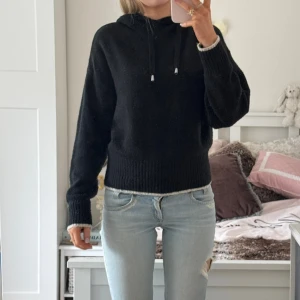 Svart stickad hoodie från H&M - Säljer en svart stickad hoodie från H&M med dragsko i huvan och ribbade muddar vid ärmslut och nederkant. Perfekt för en avslappnad och stilren look. ⊹ jag är 173cm & stl S/36/28 för referens ⊹ läs POLICY (i gillade inlägg) innan köp ⊹ använd gärna ”Köp” ⊹ 