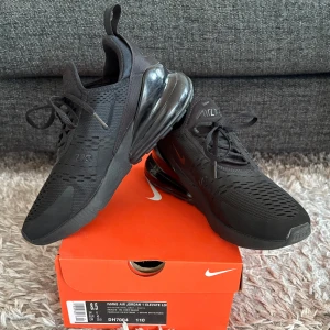 Nike Air Max 270 helsvarta sneakers - Säljer ett par helsvarta Nike Air Max 270 i absolut nyskick! Skorna har mesh-överdel för bra andningsförmåga och klassisk snörning. Perfekta för dig som gillar en sportig och stilren look. Nypris 1 799 kr
