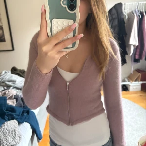 Rosa stickad hoodie med dragkedja - Säljer en rosa stickad hoodie från Hallhuber i storlek M men är väldigt liten i storleken så passar snarare en S. Tröjan har dragkedja framtill, huva och är croppad i modellen. Perfekt för lager-på-lager och en chill look. 