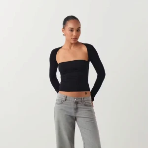 Svart långärmad topp - Trendig svart topp med långa ärmar. Nästan helt oanvänd. Säljer pågrund av att den inte används.