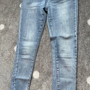 Blå skinny jeans från Redial - Säljer ett par klassiska blå skinny jeans från Redial. Jeansen har en ljus tvätt och smal passform med normal midja. Perfekta till vardags och lätta att matcha med olika toppar.