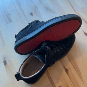Svarta sneakers från Christian Louboutin - Svarta skor från Christian Louboutin som är ÄKTA! Skick 4/10 och storlek 46. Om ni har några frågor om bilder eller bara allmänt är de bara att fråga. Priset är ej hugget i sten och kan gå ner i pris vid snabb affär.