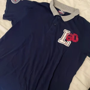 Lonsdale skjorta  - Mörkblå skjorta/piké från Lonsdale med vita och röda detaljer. Pris går att diskutera❤️