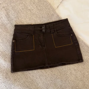 Brun denimkjol - Skitsnygg kjol med gul/orange detaljer! Älskar färgen🧡passar S
