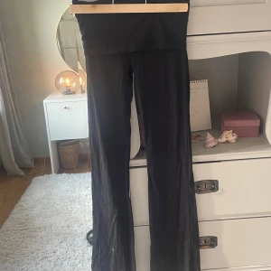 Svarta yoga byxor  från Gina Tricot - Svarta leggings från Gina Tricot med hög midja och stretchigt material. De är tighta och har en enkel, stilren look som passar perfekt till en avslappnad outfit. Mjuka och bekväma att bära hela dagen.