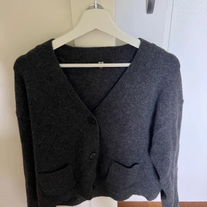 Mörkgrå kofta från Uniqlo, storlek M - Säljer denna mysiga snygga mörkgrå kofta från Uniqlo i storlek M. Koftan är stickad, har tre knappar framtill, djup v-ringning. Den är perfekt till hösten och är jätte skön!!💖💖 har andvänt 10 tal gånger💖 skriv vid intresse eller om ni vill ha fler bilder 💖