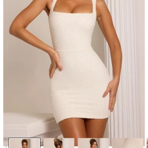 Vit glittrig kortklänning med breda axelband - Supersnygg vit kortklänning med glittriga detaljer och breda axelband. Klänningen har en tight passform och fyrkantig urringning som framhäver figuren. Perfekt för dig som vill sticka ut med en elegant och modern look.