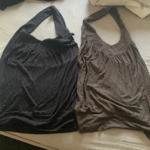Svart och brun halterneck toppar❤️ - Två enkla och snygga halterneck tippar med djup rundad halsringning. Lätt rynkade detaljer framtill ger en avslappnad vibe. Perfekta för varma dagar eller lager på lager. Säljes tillsammans! Vintage. Strl S men passar även M