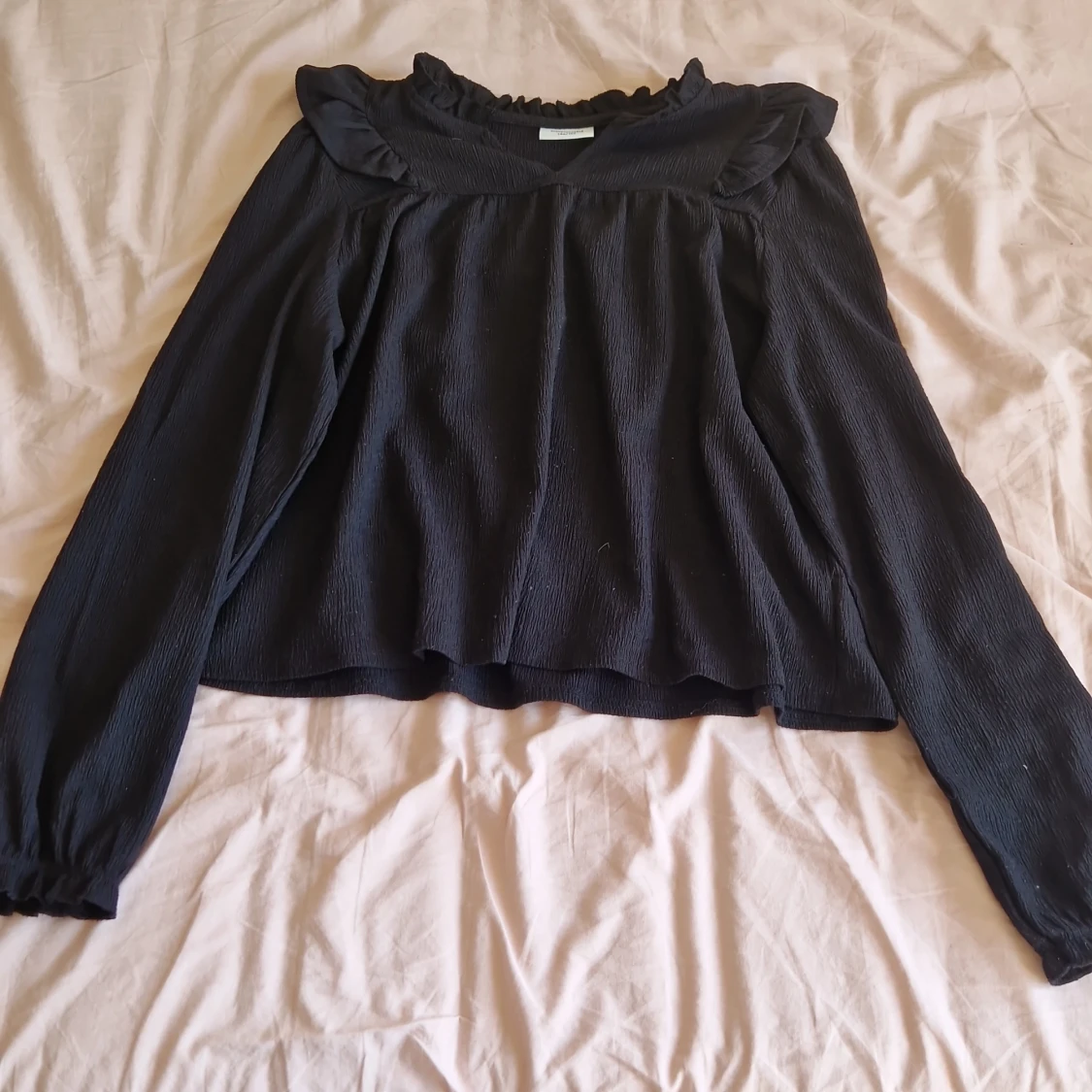 Svart blus med volang från Kappahl