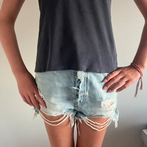 Ljusblå jeansshorts med fransar  - Trendiga jeansshorts i ljusblå tvätt med råa kanter, fransar och trasiga partier framtill (design). Only, storlek M, bra skick. Nypris 399 kr – säljes för 150 kr! 💖💖
