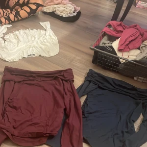 Vinröd offshoulder topp Gina Tricot - Säljer en vinröd och en mörk blå offshoulder topp från Gina Tricot med långa ärmar och snygg rynkning på sidorna. Materialet är mjukt och stretchigt, perfekt för dig som gillar en lite mer unik och trendig look. Passar dig som vill sticka ut med en cool färg och offshoulder-stil.