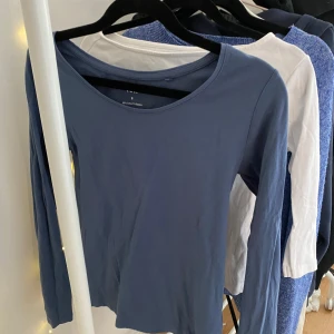 Blå långärmad tröja i bomull - En enkel och stilren blå långärmad tröja med rund halsringning. Tröjan är gjord i mjuk bomull och passar perfekt till jeans eller kjol. Snygg att ha lager på lager eller bara som den är. Perfekt för dig som gillar en clean look.