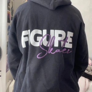 Svart hoodie - En fin svart hoodie där det står Figureskating på ryggen. Storlek 146/152
