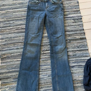 Blå bootcut jeans från Zara - Snygga blå jeans från Zara med klassisk bootcut-passform. Jeansen har fem fickor, normal midja och är tillverkade i ett mjukt bomullsmaterial med lite stretch. Perfekta för dig som gillar en tidlös och avslappnad look.