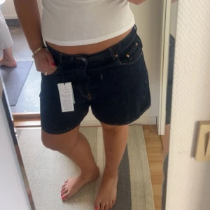 Mörkblå jeansshorts med lågmidja - Coola lågmidjade shorts från Gina, endast använda 2 gånger!! Storlek 42 men passar typ M också beroende på hur man vill att de ska sitta!!