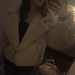 Mysig Teddyjacka - Supermysig beige teddyjacka med oversized passform och stor krage. Jackan har dragkedja framtill och är perfekt för kalla dagar. Den fluffiga looken ger en chill vibe och passar grymt till både jeans och mjukisbyxor.