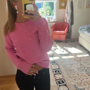 Ljusrosa stickad tröja - Supermysig ljusrosa stickad tröja med rund hals och långa ärmar. Tröjan har en enkel, clean look och är perfekt att matcha med svarta jeans. Materialet är mjukt och skönt mot huden, och färgen ger en fräsch vibe till din outfit.💛