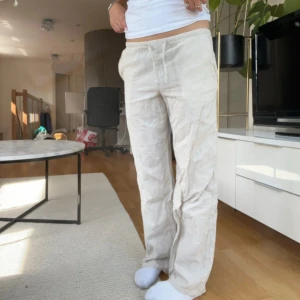 Beiga linnebyxor från Gina Tricot - Snygga och luftiga beiga linnebyxor från Gina Tricot. Byxorna har raka ben och är tillverkade i mjukt linnematerial. Endast använda en gång