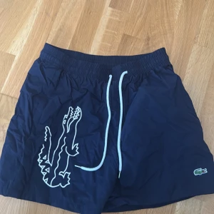 Lacoste badshorts  - Marinblå Lacoste badshorts storlek L passar m