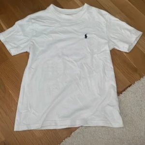 Vit t-shirt från Polo Ralph Lauren - Vit klassisk t-shirt från Polo Ralph Lauren med broderad marinblå logga på bröstet.💕