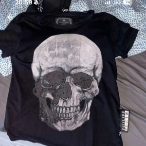 Svart t-shirt med döskalle från Philipp Plein - Svart t-shirt från Philipp Plein med Platinum Cut, stor grå döskalle