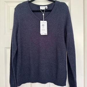 Mörkblå stickad V-ringad tröja Vila - Mörkblå stickad tröja från Vila med V-ringning och långa ärmar. Aldrig använd, prislappen sitter kvar. Nypris 329 kr.