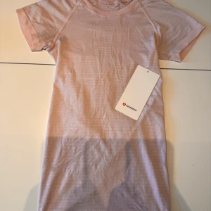 Rosa Swiftly Tech T-shirt - Lululemon - En swiftly tech tshirt från lululemon i färg pink haze, storlek 0 (32/xxs). Den är skön och luftig så den är perfekt för att springa och träna. En ny kostar 740kr! 