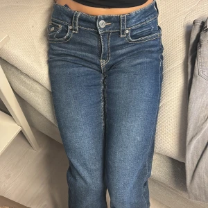 Blå bootcut jeans med kontrastsömmar - Low waist mörkblåa jeans från Gina Young i storlek 164. Helt nytt skick utan användning som är köpta på ordinarie pris på 349 kr. Jag säljer jeansen för att dom är lite korta på mig som är 164 cm.