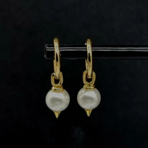 Guldiga örhängen med pärldetalj - Snygga örhängen i guldton med rund vit pärla och cool spetsig detalj nedtill. Perfekt accessoar för att lyfta din stil med en mix av klassiskt och edgy vibe.