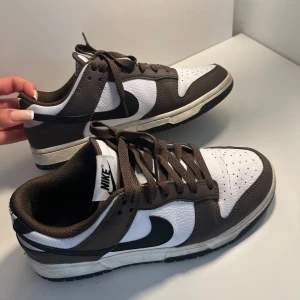 Nike Dunk Low i brunt och vitt - Snygga Nike Dunk Low sneakers i brunt och vitt med svart swoosh. 