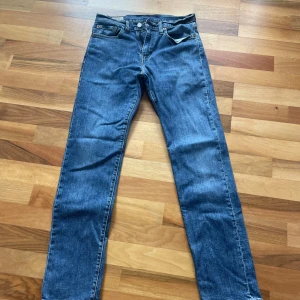 Levi's 502 Premium blå jeans - Klassiska Levi's 502 Premium jeans i blå denim. Rak passform med fem fickor, knappgylf och snygga kontrastsömmar. Ikonisk läderpatch bak i midjan och Levi's röda etikett på bakfickan. Perfekta för en avslappnad och tidlös stil.