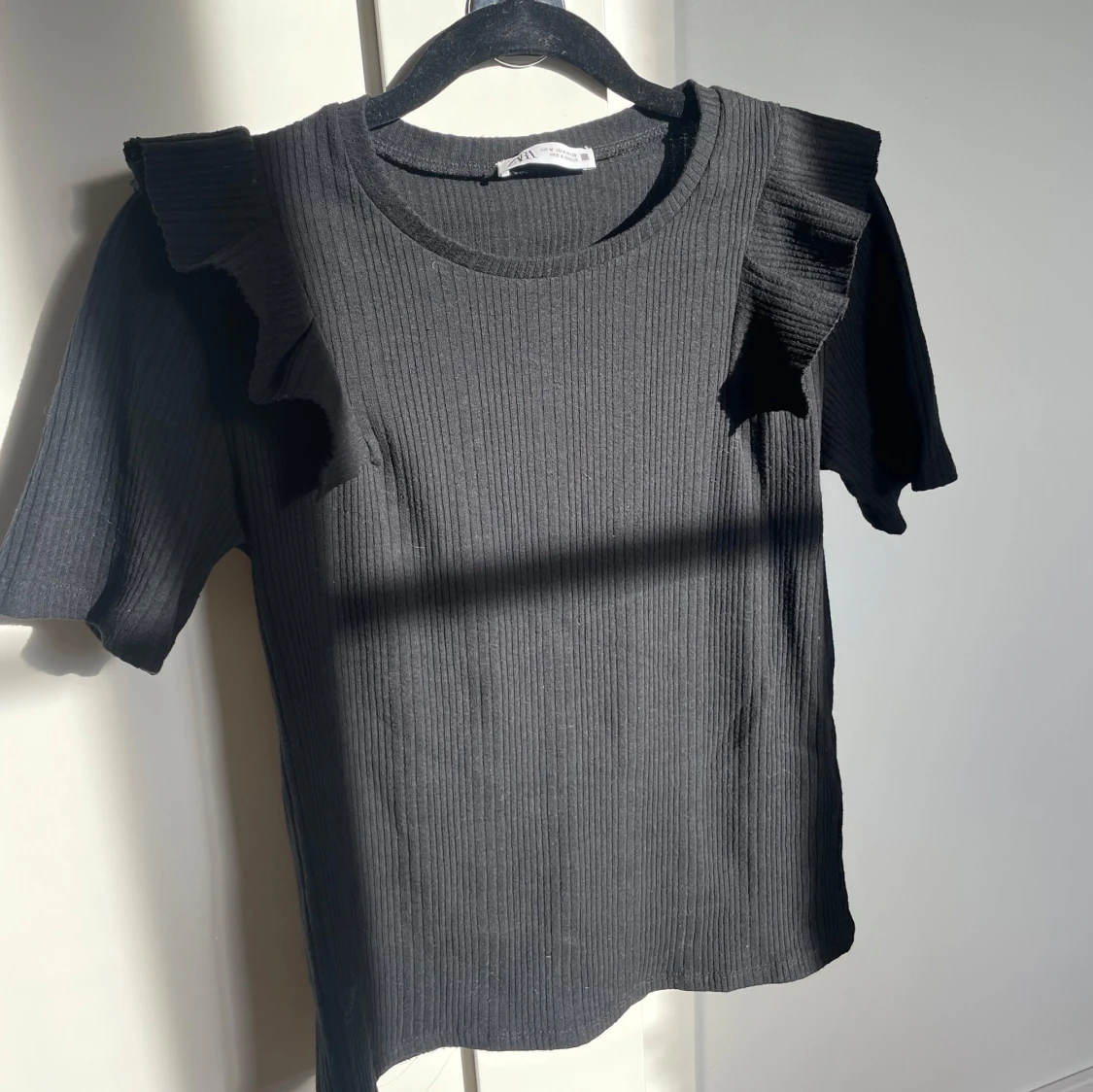 Svart T-shirt med volanger. - 1