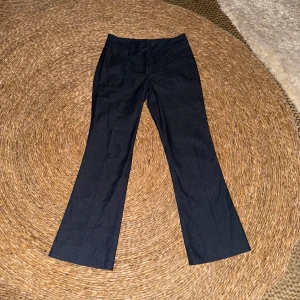 Svarta bootcut byxor Gina Tricot - Mörkblå/grå kostymbyxor i strl 36                                    Midjemått rakt över: 35  grenmått: 22 innerbens längd:  73. Inga slitningar eller märken på användning, köpta och nästan aldrig använda. 