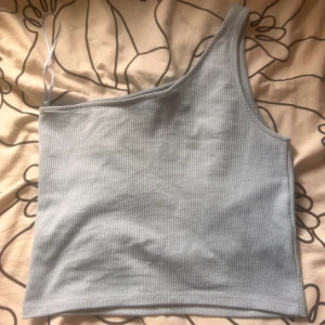 Ljusblå oneshoulder topp - Supersnygg ljusblå top. Inte använd.