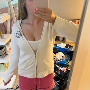 Vit hoodie med dragkedja från hollister - Mysig vit hoodie med dragkedja framtill och huva. 
