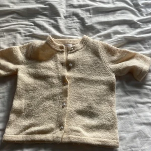 Beige ullkofta från Gina Tricot - Supermysig beige kofta från Gina Tricot i ullmix. Koftan har rund halsringning, knappar framtill och en lite fluffig, stickad känsla. Perfekt för lager-på-lager och passar till allt. Enkel och stilren design som är lätt att matcha.