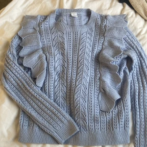 Ljusblå stickad tröja med volang - Supersöt ljusblå stickad tröja från Lindex med volangdetaljer längs axlarna. Tröjan är i stl 146/152 men den är jätte töjbar, passar mig som har xs-s. 💕