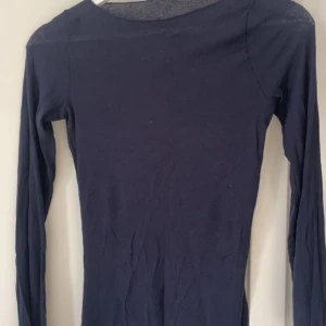 Marinblå långärmad tajt topp från Intimissimi i storlek S - En långärmad tajt topp från Intimissimi i storlek S. Det finns två hål på ena ärmen och därav priset. Jättefint basplagg