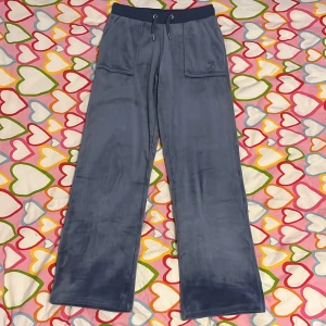 Blå velourbyxor Juicy Couture 10/11 (år) - Mysiga blå mjukisbyxor i storlek 10/11 (år) från Juicy Couture i mjuk velour. Byxorna har bred resår och snörning i midjan, stora fickor fram och bak samt broderad JC-logga på ena fickan. Passar både till vardag och fest! Dom är endast använda ett fåtal gånger så det vill säga att dom är i mycket bra skick.