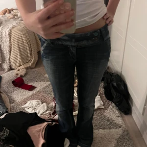 Mörkblå bootcut jeans från Vero Moda - Storleken är xs men om ni vill ha mått eller andra frågor är det bara att säga till!!                                                                                 Snygga mörkblå bootcut jeans från Vero Moda med slitningar och cool tvätt. Låg midja och klassisk femficksmodell. Jeansen har dubbla knappar i midjan och är tillverkade i bomull med en skön jeanskänsla.