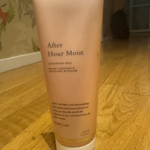 After Hour Moist Body Lotion MONSUN - Body lotion med doft av varma mandlar och blomster, innehåller närande oljor och vitamin E. Ger silkeslen och återfuktad hud. Kommer i en ljusrosa tub på 225 ml, perfekt för dig som vill ha en lyxig känsla i din hudvårdsrutin.