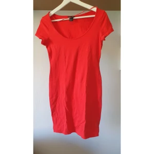 Röd bodycon klänningfrån H&M Basic - Enkel och snygg röd klänning från H&M Basic i bodycon stil. Klänningen har rund halsringning, korta ärmar och är figurnära i modellen. Perfekt för dig som gillar en clean och stilren look. Tillverkad i mjuk bomull som är skön mot huden. 95% bomull, 5%elestan