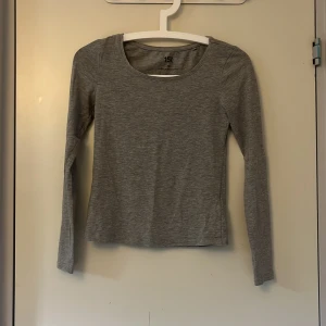 Grå långärmad tröja från 157, XS - En basic grå långärmad tröja från 157 i storlek XS. Tröjan är i mjuk bomullsblandning med rund halsringning och smal passform. Perfekt att styla med jeans eller kjol för en enkel och clean look. Liten sliten på vissa ställen (se bild 4) men annars i fint skick.