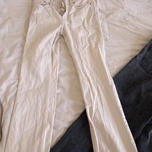 Vita raka jeans från Weekday - Säljer ett par vita jeans från Weekday i modellen Pin. De har raka ben, klassisk femficksdesign och knäppning med knappar. Jeansen är i bomull och har en snygg, enkel look som passar till allt.