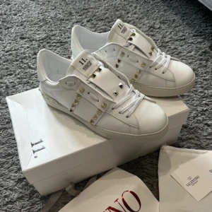 Valentino Opens med silver nitar  - Helt nya Valentino Opens med silver nitar. 10/10 skick. De är använda 2 gånger, jag väljer att sälja dem eftersom det inte riktigt är min stil. De har inga skador eller liknande, de är bara lite smutsiga på sulan, annars är det inget fel på dem. Alla nitar sitter på dem. Allt på bilderna medföljer. Det är Unisex skor. Det är storlek 43 och de sitter som 43. Riktigt snygga och bekväma, perfekt för sommaren. Hör av er vid intresse och funderingar!