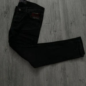 Svarta jeans från Zara Man Vintage - Svarta jeans från Zara Man Vintage med broderad detalj på fickan. Klassisk femficksmodell i bomull med snygg, rak passform. Perfekta för dig som gillar en stilren look med lite edge.