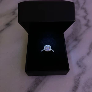 Stilren silverring med fyrkantig kristall - Levereras i LED-presentask - Upptäck elegansen i enkelhet. Denna helt nya ring i äkta 925 sterling silver med snyggt slipad fyrkantig sten fångar upp ljuset från varje vinkel. Oanvänd och direkt från lagret! Levereras i en exklusiv LED-box som gör det lilla extra. Vid köp av alliansring eller 2 ringar blir priset 799 kr. Finns i storlek 16,18. Alliansring finns i 16,17,18. 